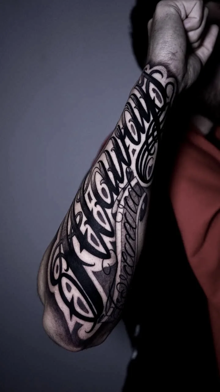 Tatuaje de lettering en el antebrazo en tinta negra