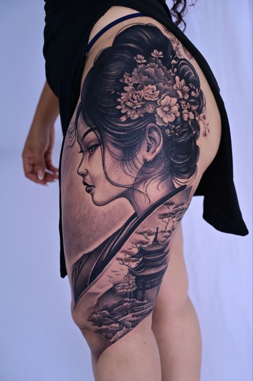 Tatuaje de retrato de gueisha en black and grey en el muslo, en Black Rituals Málaga